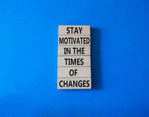 Motivation and changes symbol. Concept words Stay motivated in the times of changes on wooden blocks. Beautiful blue background. Business concept. Copy space.