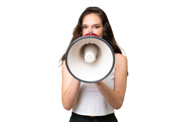 Young caucasian woman isolated over isolated background shouting through a megaphone