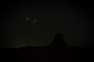 Mesmerizing starlit sky with a silhouette of the Devils tower under it at dark night