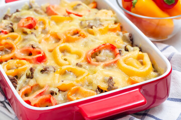 Casserole with potatoes, sausage and colorful bell pepper, in baking dish, horizontal, closeup