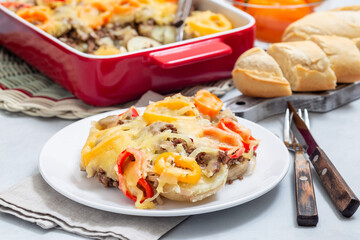 Delicious casserole with potatoes, sausage and colorful bell pepper, on plate, horizontal
