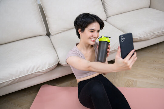 An Asian young woman is workout on fitness mat , exercise at home , healthy lifestyle concept