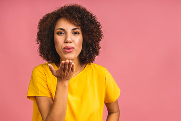 Fototapeta na wymiar Portrait of beautiful positive african american black business woman standing isolated over pink background. Sending air kiss.