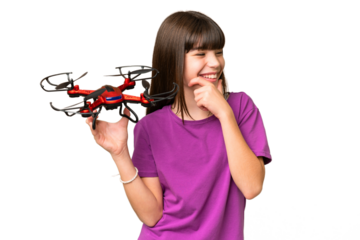 Little caucasian girl holding a drone over isolated background thinking an idea and looking side