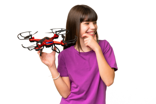 Little caucasian girl holding a drone over isolated background thinking an idea and looking side