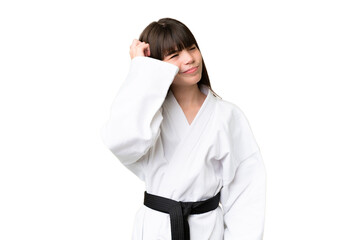 Little Caucasian girl doing karate over isolated background having doubts and with confuse face...