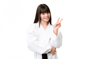 Little Caucasian girl doing karate over isolated background smiling and showing victory sign