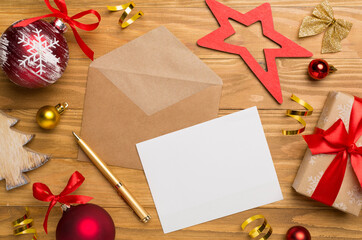 Craft envelope with christmas decoration on wooden background, top view