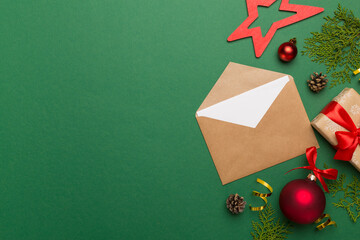 Craft envelope with christmas decoration on color background, top view