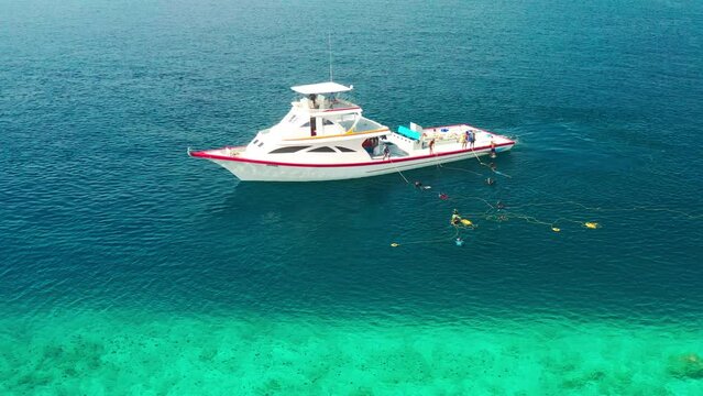 Local fishermans boat set up fishing nets in the sea to catch fish on local island in Maldives. Aerial drone view.