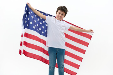 Happy American citizen, a teenage boy wearing casual t-shirt and blue denim jeans, carrying a flag of USA, celebrating the independence Day on July 4th. Concept of freedom, liberty and citizenships