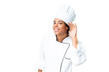 Young African American chef over isolated chroma key background listening to something by putting hand on the ear