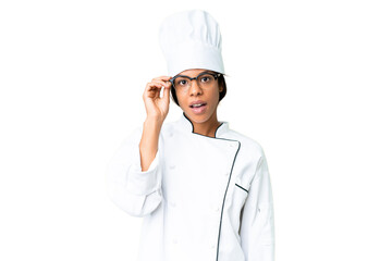 Young African American chef over isolated chroma key background with glasses and surprised