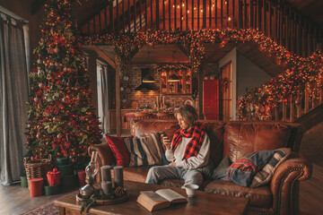 Portrait of candid authentic smiling handsome boy teenager using mobile phone at Xmas home interior