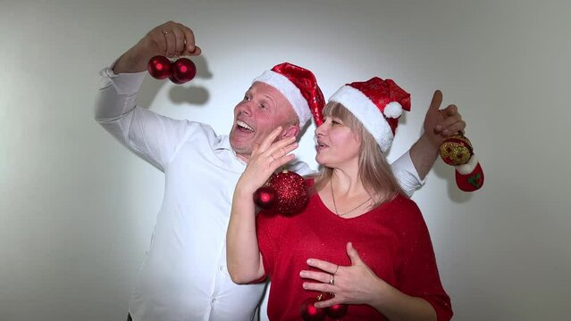 party invitation New Year and Christmas man and woman adult dancing in their hands with toys They have Christmas hats on their heads and red balls Ded Moroz Santa Claus Snow Maiden