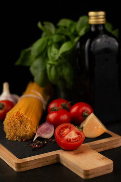 Blurred image of tomatoes, spaghetti, peppers, garlic, parmesan, olive oil and basil in the background.
