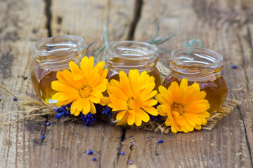 honey and calendula flowers on wooden  background