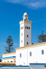 Low-angle view of the masjid's minaret against a blue sky.