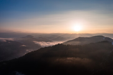 Carpathian peaks in the morning in the clouds, top view, drone footage.