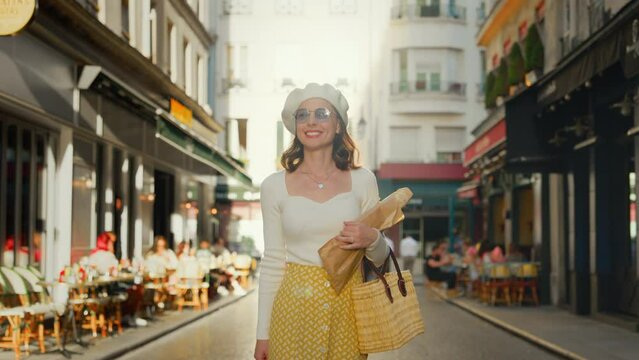 Attractive young tourist with baguettes walking from a bakery in Paris
