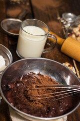 Ingredients for cooking chocolate pastry from above on wooden background
