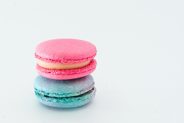 Brightly colored stacked up French macarons on white. Tasty colourful macaroons. Blue and pink macaroons isolated on white background. French pastry made from egg whites. Concept of food, desserts