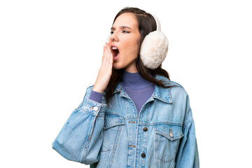 Young caucasian woman wearing winter muffs over isolated background yawning and covering wide open...