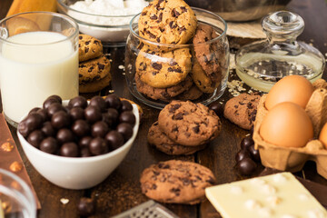 Preparing homemade chocolate chip cookies. Ingredients for preparing and baking cookies. Ingredients includes are flour, eggs, chocolates, chocolate chips, sugar,  milk,  butter, and equipment