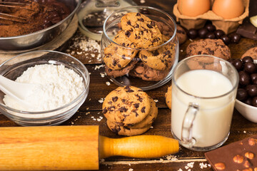 Preparing homemade chocolate chip cookies. Ingredients for preparing and baking cookies. Ingredients includes are flour, eggs, chocolates, chocolate chips, sugar,  milk,  butter, and equipment