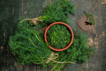 Chopped fresh dill on a cutting Board and a bunch of dill preparation for freezing serving size...