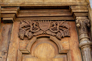 part of the decor and the material from which it is made;
old wooden door with carved details and the date of its creation
