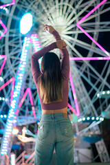Woman on her back with the lights of a Ferris wheel in the background