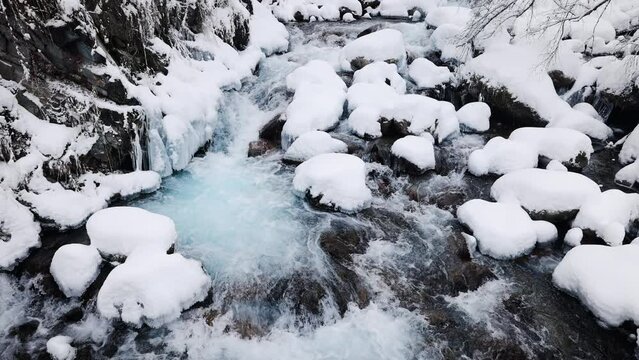River stream at winter snow forest in the mountains