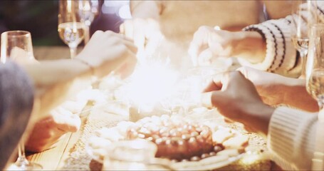 Sparklers, sparks and people at christmas party dinner together in dining room at house. Celebrate, fireworks and friends at festive holiday lunch or feast for xmas celebration event with decoration.