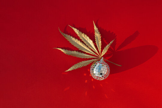 Abstract christmas background with mirrored disco ball and gold marijuana leaf.