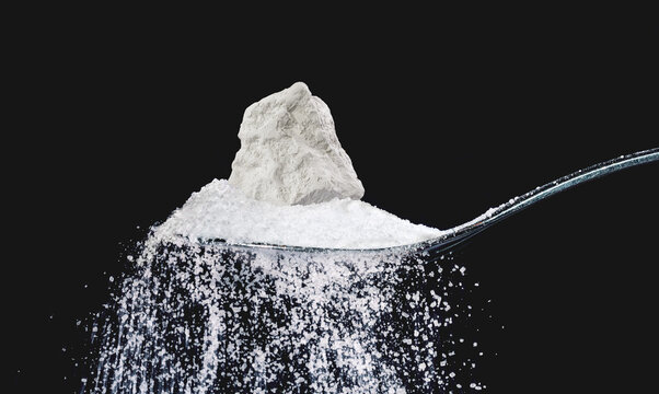 Natural food chalk of mountain origin peeled in a tablespoon on a black background