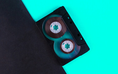 Black audio cassette on blue and black background