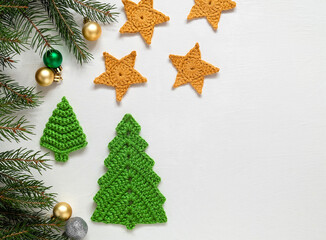 Festive Christmas composition on a white background. Handmade crochet green Christmas tree and yellow stars. Christmas craft ideas. Copy space.