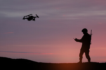 Fototapeta na wymiar Silhouettes of soldiers are using drone and laptop computer for scouting during military operation against the backdrop of a sunset. Greeting card for Veterans Day, Memorial Day, Independence Day.