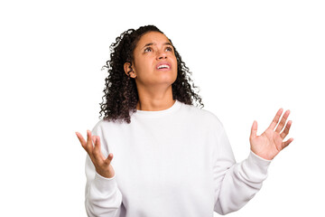 Young Brazilian curly hair cute woman isolated screaming to the sky, looking up, frustrated.