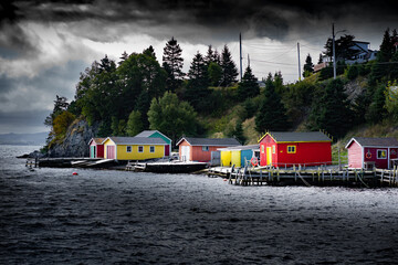 Boat sheds during a stormy day painted in different colours along the East coast of Canada in Dildo Newfoundland.