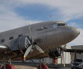 A hawk perched on a DC-3 airplane.