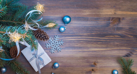 Flat lay christmas composition with fir branches and christmas decorations, gift box on a wooden table. Winter holiday background with copy space