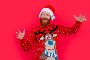 smiling bearded man celebrate christmas with music. man in headphones listen christmas music