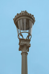 Fototapeta na wymiar A Fernandina-style lamppost on blue sky in a park in Madrid. Spain