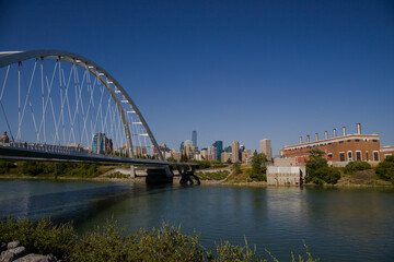 Fototapeta na wymiar Modern arc bridge over the river, day traffic, summer time. modern architecture, panorama of the city Edmonton