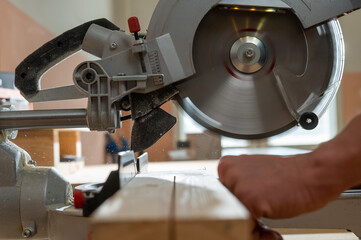 Master cuts the board with a circular saw in the workshop. 
