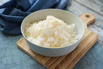 slice of fresh coconut flakes in a bowl on a table 