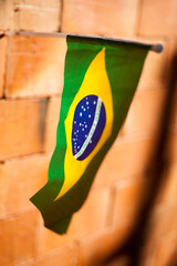 flag of brazil fluttering, hanging on brick wall
