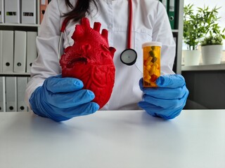 Cardiologist doctor with red heart and pills in hospital